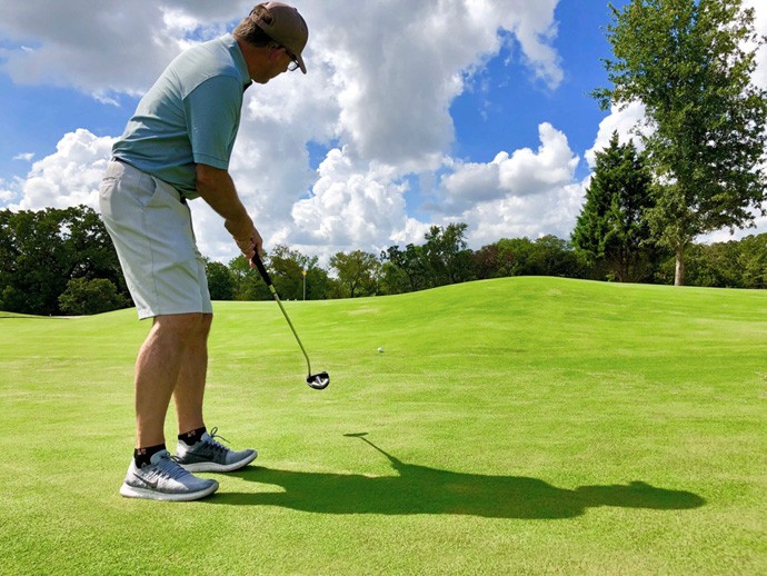 Golfer with a long putt on the large putting green