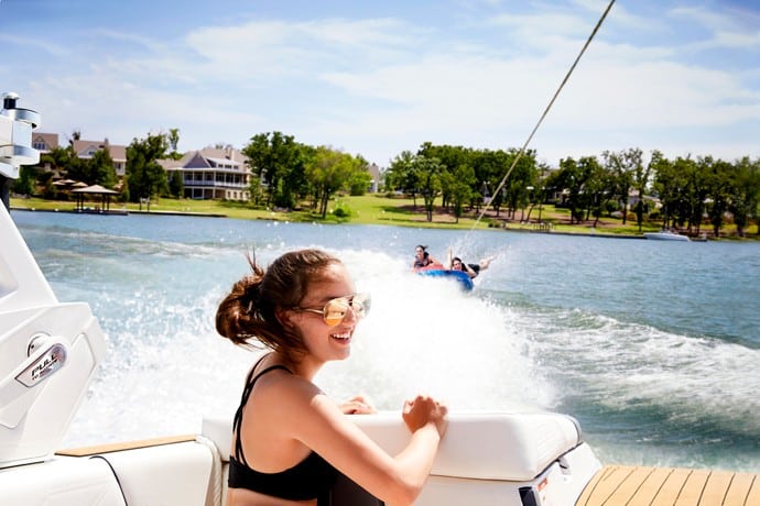 Woman watching her boat pull kids on a float