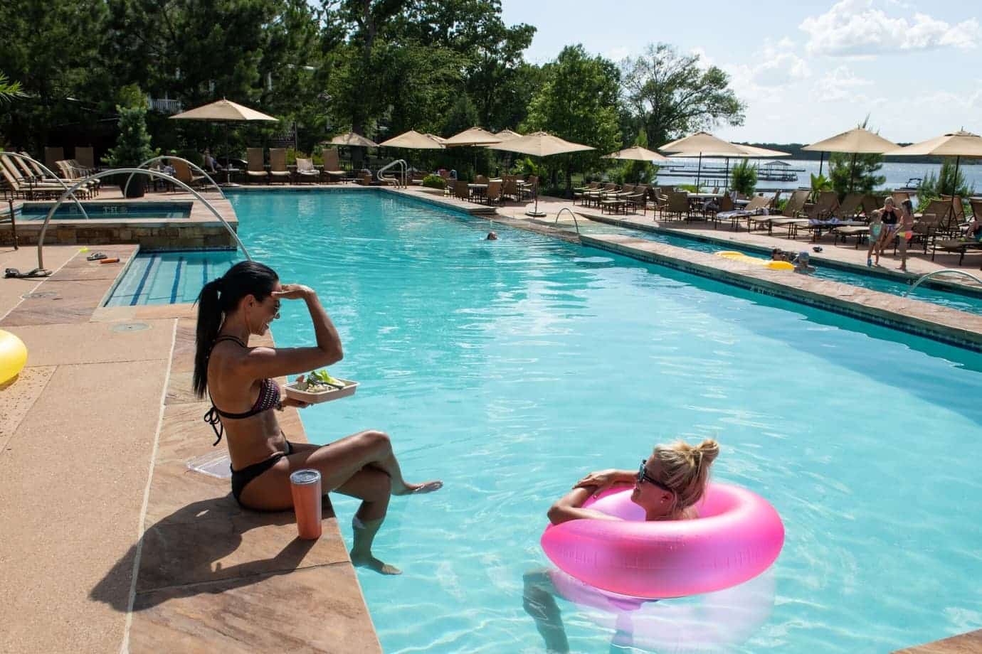 2 women enjoying the community pool at long cove