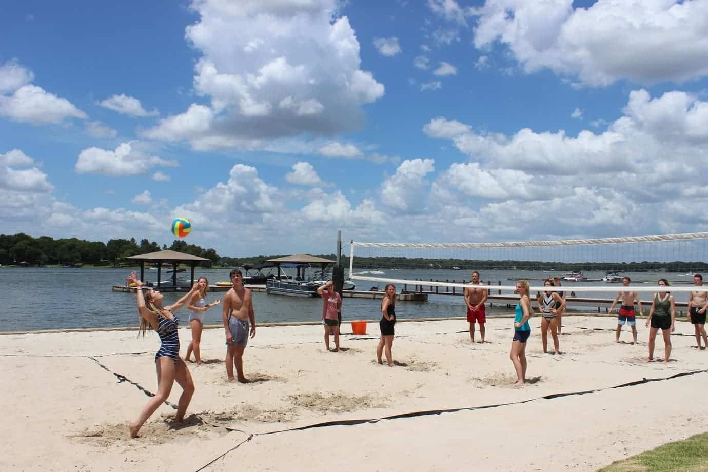 Many great ways to play at Long Cove like these friends playing sand volleyball on the beach of the lake