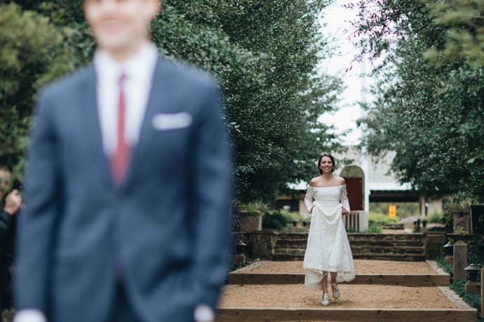 A bride stands behind the groom for a long cove love story