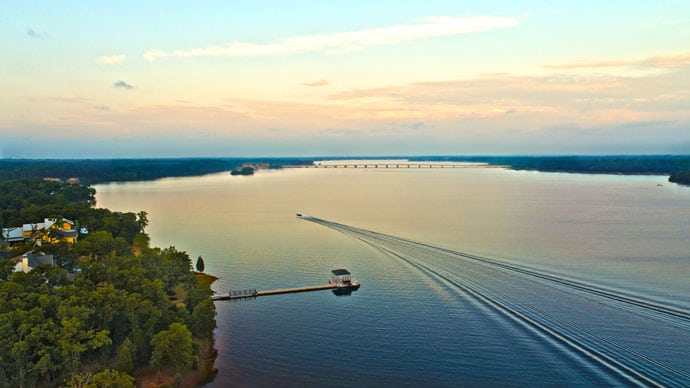 a boat making a wake for life's better at the lake