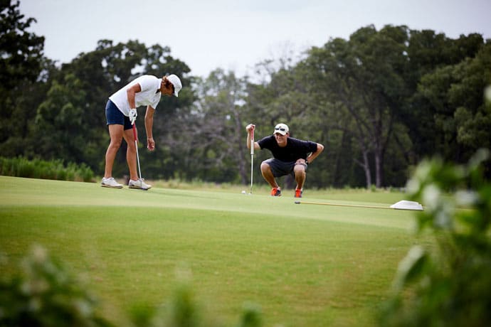 Golfers lining up a putt on the putting green at Long Cove