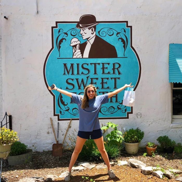 Woman in front of Mister Sweet Tooth sign