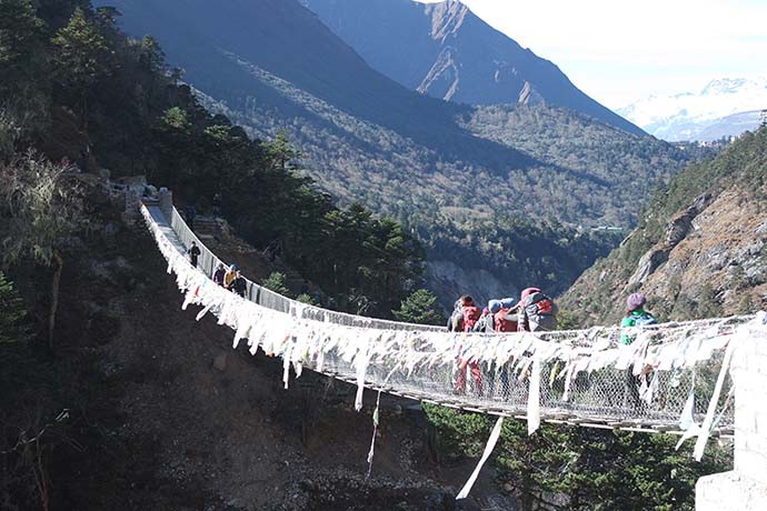 Hikers walking across a suspended bridge