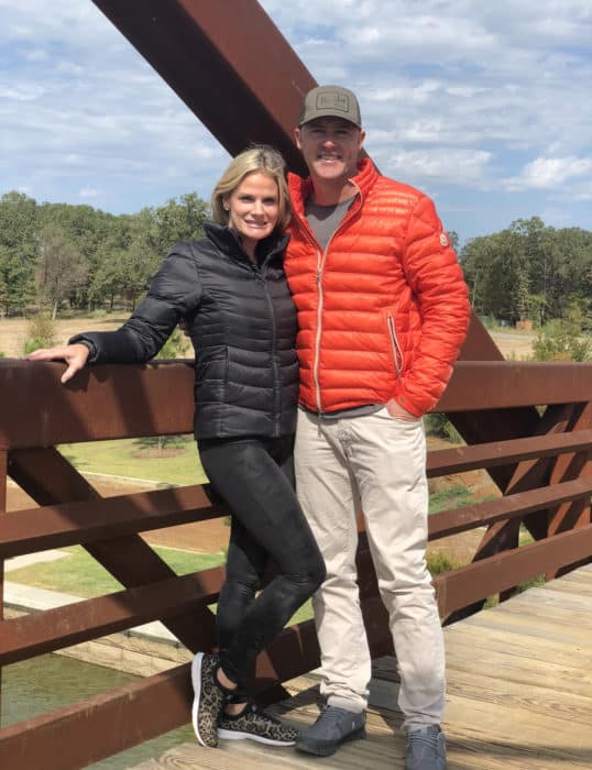 Couple in jackets standing on the Hennybay Bridge at Long Cove